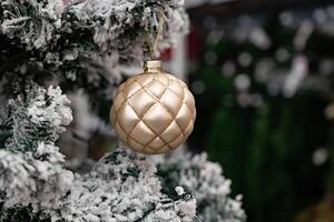 close view of holiday decorations on a Christmas tree, emphasizing pink and burgundy-colored ornaments and a butterfly. photo