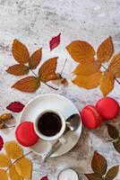 A top-down view of a cozy holiday scene showcasing a cup of coffee, alongside gingerbread cookies, cinnamon sticks, candy canes, candles, and fresh pine branches. photo