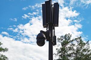 Surveillance camera on a pole with clear sky background. photo
