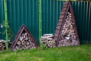 Stacked firewood in wooden shelter in garden.. photo