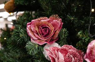 The image captures a Christmas tree with various ornaments in pink and burgundy tones, highlighted by a butterfly decoration. photo