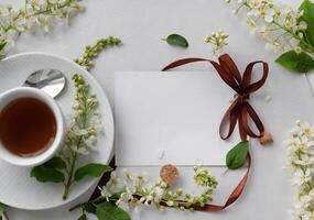 A white cup filled with tea is placed on a matching white saucer. photo