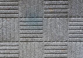 Close-up of patterned concrete texture with grooves and rough surface. photo