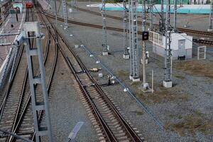 Railway tracks and signal lights near a transit station during the early morning hours photo