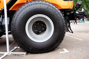 tractor wheel with orange rim on grassy ground. photo