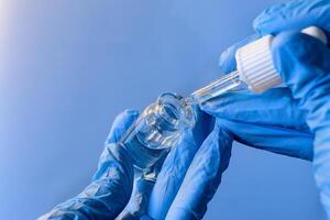 Preparing a solution using a dropper and vial in a laboratory setting with a focus on precision and safety photo