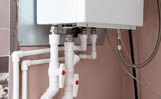 Plumbing system showcasing a modern water heater and connected piping in a residential utility area photo