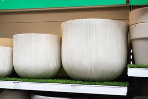 Textured stone planters displayed on shelves in a garden store. photo
