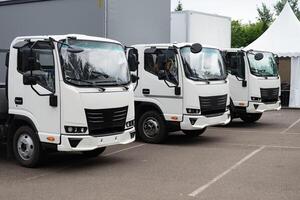 Fleet of white delivery trucks parked in a lot. photo