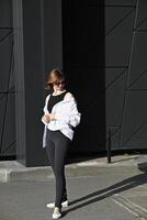 The outfit is complemented by black shoes, which are partly visible beneath the wide trousers. photo