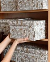 Storing decorative boxes on a wooden shelf in a cozy modern interior space during daylight hours photo