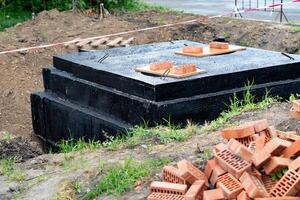 Construction Site Showing Foundation Blocks and Bricks Prepared for Building in a Rural Area During Daytime photo