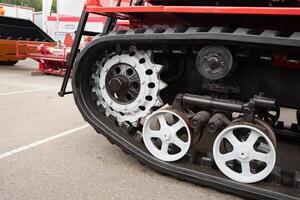 Close-up of red tracked vehicle's wheels system. photo