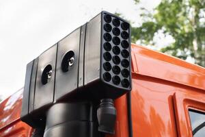 Close-up of a modern vehicle-mounted surveillance system on an orange truck. photo