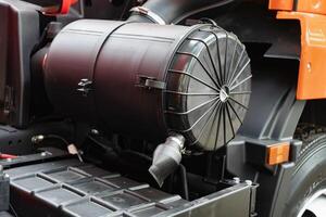 Close-up of a truck air filter housing and exhaust pipe on industrial machine. photo