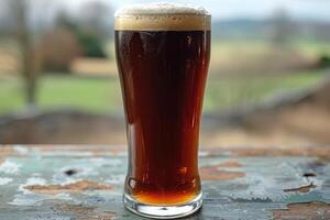 Dark drink in tall glass against out-of-focus background. photo