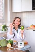 Nutritionist with avocado and capsule of dietary supplement at table with healthy products. Avocado is rich in omega-3 and helps in weight control. Dietetics concept, health. photo