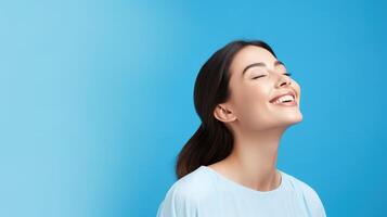 Smiling woman with eyes closed on blue background photo