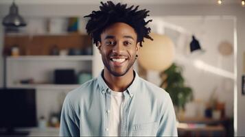 A young man with dreadlocks smiles at the camera photo