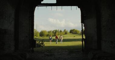 Three friends are walking near the ruins of a historic building. A sunny summer day photo