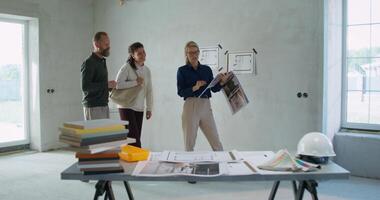 The designer talks to a married couple while discussing the design project of their house photo