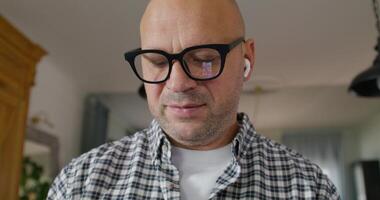 Portrait of a man when he talks on earphone. He's smiling at the camera, close-up of his face photo