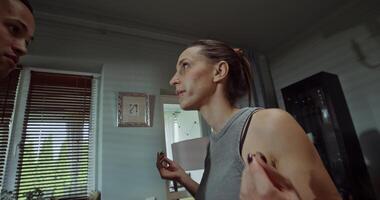 Husband and wife yell at each other and jostle while standing at home. A family quarrel photo