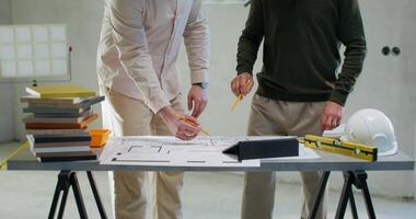 The foreman communicates with the customer, they study the house plan standing in a room without decoration photo