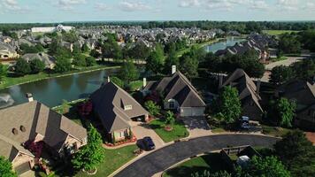 A drone view of a residential area in America. A picturesque lake with fountains among the cottages. Low-rise buildings. Summer day photo