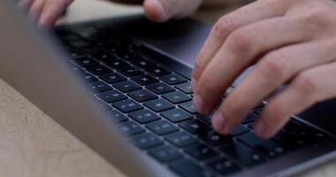 Close-up of a man's hands and keyboard as he taps on a laptop. photo