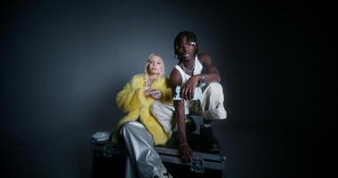 Glamorous photo shoot in the studio. A man and a woman with bundles of dollar bills. A woman throws money around