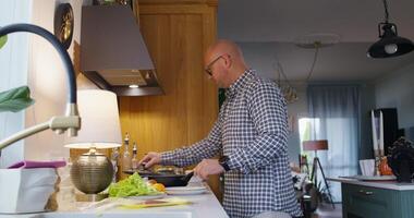 A man Cooks breakfast at home. He pours oil into the pan and starts frying photo