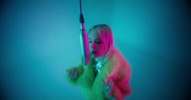 The singer moves her hands rhythmically when she sings into the microphone. Studio photo
