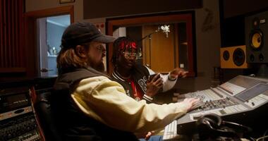 Listening to the song after recording in the studio. The sound engineer and the performer are sitting in front of the monitor in the control room photo