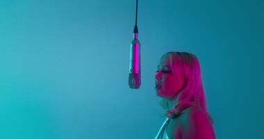 A rapper and a glamorous woman sing into a microphone together. Recording music in the studio photo