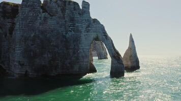 Natural monument of France, the most picturesque place on the bank of the English Channel - sheer cliffs with natural arches, washed by water sparkling in the sun, Etretat photo
