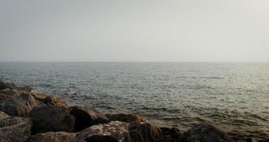 Panoramic view of the sea with small ripples of waves. Daylight is reflected in the water. filming from the rocky shore. 4k , red komodo photo