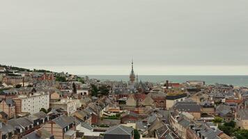 Horizontal panning from a drone, a view of an old European city located on the banks of the English Channel. The tower of the Benedictine Palace rises above roofs of historic houses, F camp, France photo