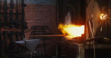 A metal blank lies in a furnace with a kindled fire. Hot metal, no people, details of work in a modern forge. 4k , red komodo photo