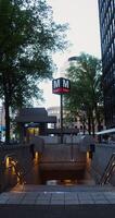 View of the entrance to the underground metro station, equipped with an elevator and located between residential buildings in Amsterdam, the Netherlands. 4k vertical , red komodo photo