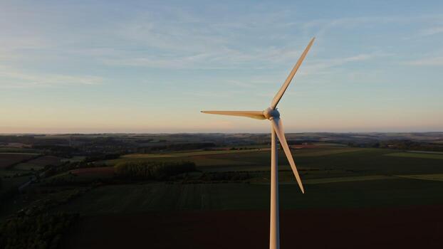 The drone flies at the level of the rotating blades of the wind generator around the propeller. Multicolored beautiful fields in the background, the Netherlands. photo