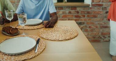 A woman puts a baking tray with a roast on the table, a close-up of her hands photo