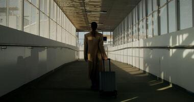 A woman in a coat with luggage in her hand walks through the railway station, she turns around looking at the camera photo