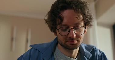 A man with glasses works at home. Close-up of his thoughtful face photo