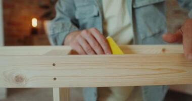 A man polish a rack with sandpaper in a stylish home interior, close-up of his hands, no face photo