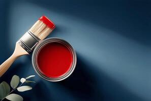 brillante rojo pintar y cepillo Listo para un creativo proyecto en un elegante espacio de trabajo con azul antecedentes foto