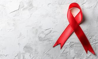 Red Ribbon Symbolizing Awareness and Support for Health Causes Displayed on a Textured Background photo