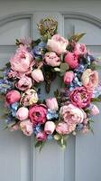 Bright Floral Wreath Adorns a Door Decorated With Pink and Blue Flowers During Springtime photo