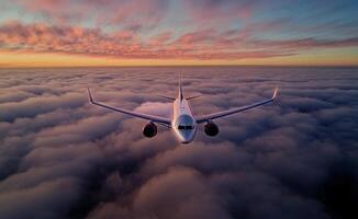 Airplane Flying Above Clouds During Colorful Sunset in the Sky photo
