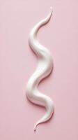 Creamy White Swirl on Pink Surface Creating a Smooth Texture and Visual Appeal photo